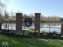 Community entrance sign for Fishers Pointe, with landscaping and a pond behind a wrought iron fence at 8010 Philadelphia Dr, Fishers, IN 46038