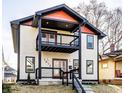 Two-story home with eye-catching red and black accents, a second story balcony, and covered entry porch at 1015 Churchman Ave, Indianapolis, IN 46203
