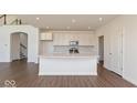 Bright, open kitchen with an island, white cabinets, and stainless steel appliances at 1105 Gatewick Ct, Greenwood, IN 46143