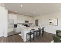 Modern kitchen boasts white cabinets, stainless steel appliances, a large island, and breakfast bar seating at 1105 Gatewick Ct, Greenwood, IN 46143