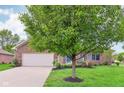 Lovely brick home with a well-maintained lawn, mature trees, and welcoming front porch at 5707 Kensington Blvd, Plainfield, IN 46168