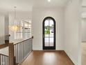 Bright foyer featuring hardwood floors, wrought iron railing, and a modern light fixture at 5469 Harness Dr, Greenwood, IN 46143
