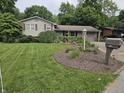 Landscaped front yard with a beautiful flower bed, a mailbox, and a well manicured green lawn at 620 Valley Dr, Martinsville, IN 46151