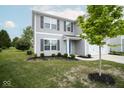 Two-story home showcasing gray siding, dark shutters, an attached garage, and a well-manicured lawn at 975 Red Hills Ct, Lebanon, IN 46052