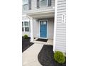 Close-up view of front entrance with blue door, white trim, a small garden, and house number at 975 Red Hills Ct, Lebanon, IN 46052