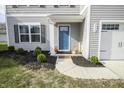 Close-up of a blue front door framed by manicured landscaping and a welcoming walkway at 975 Red Hills Ct, Lebanon, IN 46052