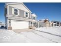 Two-story house on a snow-covered street, featuring gray siding and a white garage door at 3214 W Keepsake Ln, Monrovia, IN 46157