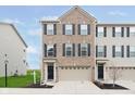 Charming brick front exterior of townhome with attached garage and well-manicured lawn at 7282 Zanesville Rd, Carmel, IN 46033