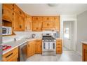 Oak kitchen cabinets, stainless steel appliances, and a gas range at 217 Federal Dr, Anderson, IN 46013