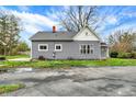 Rear exterior view of a gray house showcasing the roof, siding, and surrounding yard at 8240 Shelbyville Rd, Indianapolis, IN 46259