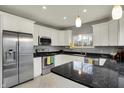 Modern kitchen with stainless steel appliances, granite countertops, and white cabinetry at 8240 Shelbyville Rd, Indianapolis, IN 46259