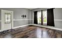 Bright living room featuring wood floors, neutral walls, and a decorative glass door at 8240 Shelbyville Rd, Indianapolis, IN 46259