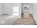Spacious foyer with both carpet and hardwood flooring, and a large window to the outside at 908 Stonehaven Dr, Indianapolis, IN 46239