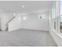 A large living room featuring gray carpet, white walls, and many large windows providing natural light at 908 Stonehaven Dr, Indianapolis, IN 46239