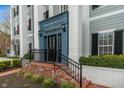 Close-up of the entrance with classical columns, brick steps, iron railings, and well-maintained landscaping at 12820 University Cres # 2D, Carmel, IN 46032