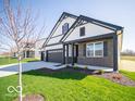 Inviting curb appeal with a three-car garage, manicured lawn, and modern design elements at 273 Lar Lan Dr, Danville, IN 46122
