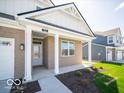 Inviting entryway with a covered porch and brick columns, leading to the front door at 301 Lar Lan Dr, Danville, IN 46122