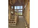 The home's entryway features a staircase with unfinished wood and large windows for natural light, exposed framing at 8030 Totton Ct, Zionsville, IN 46077