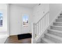 Bright entryway features wood floors, a staircase with carpet, and a front door with glass panels at 9344 Anthem Ave, Plainfield, IN 46168