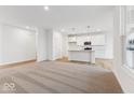 Open-concept living space with carpet and wood flooring, seamlessly connecting to the kitchen area at 235 Hunters Ridge Dr, Danville, IN 46122