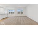 Bright and airy living room featuring neutral carpet and large windows offering backyard views at 235 Hunters Ridge Dr, Danville, IN 46122