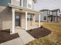 Inviting entryway with classic brick pillars supporting a cozy porch, adjacent to well-kept lawns at 7904 Magnolia St, New Palestine, IN 46163