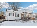 White bungalow with covered porch and snow-covered yard at 5441 E 17Th St, Indianapolis, IN 46218