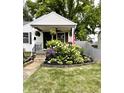 Charming home featuring a quaint front porch, beautiful landscaping and an American flag at 5441 E 17Th St, Indianapolis, IN 46218