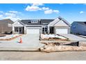 Two-unit home with gray siding, stone accents, and white garage doors at 16972 Adler Ln, Noblesville, IN 46060