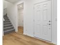 Inviting foyer featuring hardwood floors, an entry door, staircase, and access to other areas of the home at 243 Hunters Ridge Dr, Danville, IN 46122