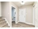 Bright foyer with a white front door, wood-look floors and stairs leading up to the next level, providing a welcoming entrance at 383 Carmelaire Ct, Carmel, IN 46032