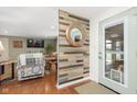 Inviting entryway with wood accent wall, decor mirror, and view into the living room at 4308 Forest Ter, Anderson, IN 46013