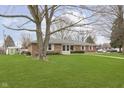Traditional brick home with a lush lawn and mature trees at 4308 Forest Ter, Anderson, IN 46013