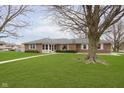 Single-story brick house featuring a well-kept lawn and large shade trees at 4308 Forest Ter, Anderson, IN 46013