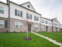 A townhome with a well-maintained lawn, showcasing a welcoming and attractive curb appeal at 6227 Rhinecliff Dr, Whitestown, IN 46075
