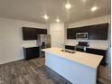 Modern kitchen featuring an island, stainless steel appliances, and dark cabinetry at 6322 Granby Dr, Whitestown, IN 46075
