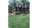 Attractive home featuring full wrap-around porch, American flag and mature trees at 1155 Cope Rd, Martinsville, IN 46151