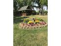 Beautiful front yard features a circular flower garden, mature trees, and a charming home at 1155 Cope Rd, Martinsville, IN 46151
