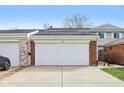 Two car garage featuring a large concrete driveway, with brick and siding exterior, and the house number above at 5527 Vin Rose Ln, Lawrence, IN 46226