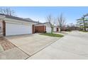 Multiple two car garages with long concrete driveways on a sunny day at 5527 Vin Rose Ln, Lawrence, IN 46226