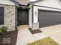 Welcoming front entrance with a dark front door, and a two-car garage at 6623 Sulgrove Pl, Indianapolis, IN 46221
