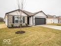 Inviting single-story home with a dark gray garage door and a freshly landscaped front yard at 6623 Sulgrove Pl, Indianapolis, IN 46221