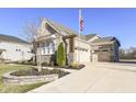 Two-car garage with stone exterior and a spacious driveway at 12535 Tidecrest Dr, Fishers, IN 46037