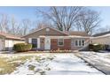 Tan house with brick accents, green lawn with snow, and a partially visible driveway at 3359 Laurel St, Indianapolis, IN 46227
