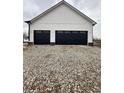Two-car garage with black doors and white siding sits on a gravel driveway at 16525 Iron Tree Ct, Westfield, IN 46074