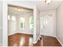 Inviting foyer with gleaming hardwood floors and abundant natural light streaming through the front door at 5171 Alpine Violet Way, Indianapolis, IN 46254