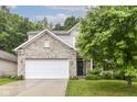 Charming two-story home featuring a well-manicured lawn and an attached two-car garage at 5171 Alpine Violet Way, Indianapolis, IN 46254