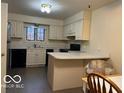 Galley kitchen with light cabinets, stainless steel appliances, and L-shaped counters at 7317 Lions Head Dr # 2, Indianapolis, IN 46260