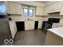Kitchen with cream cabinets, stainless steel appliances, and grey flooring at 7317 Lions Head Dr # 2, Indianapolis, IN 46260