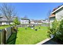 Spacious backyard featuring a lush green lawn, a wooden fence, and an outdoor entertainment area at 11218 Boston Way, Fishers, IN 46038